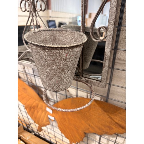 3100 - A distressed metal wall mirror features an arched, vintage-style design equipped with three built-in... 