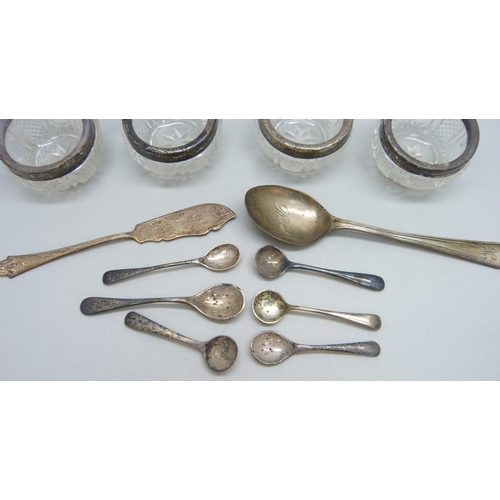 7023 - Four silver rimmed cut glass salts, six silver condiment spoons and other silver, weighable silver 6... 
