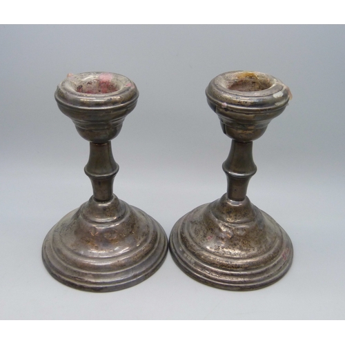 7033 - A pair of George V silver candlesticks, Birmingham, 1919, weighted bases, 325g, a/f
