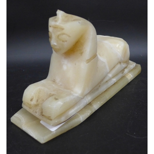 2057 - An alabaster carved Egyptian Sphinx, 19cm long, and base