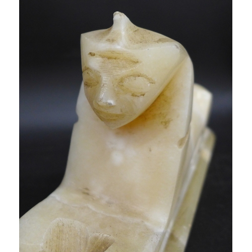 2057 - An alabaster carved Egyptian Sphinx, 19cm long, and base