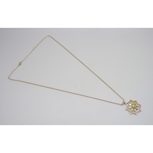 7052 - An early 20th century 9ct gold pendant set with peridot, 3.3cm including bail, on a yellow metal cha... 