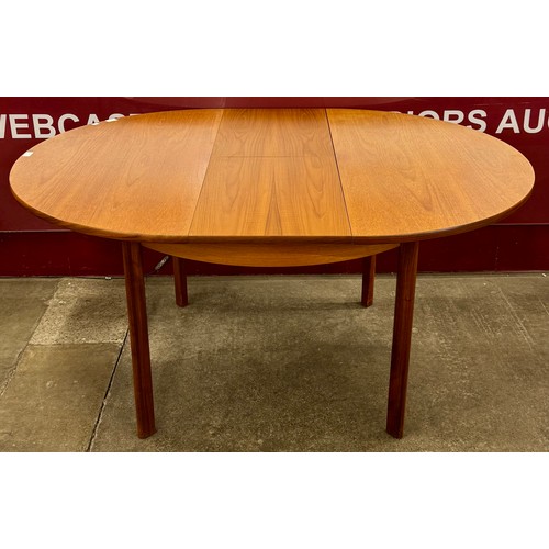 30 - A teak circular extending dining table