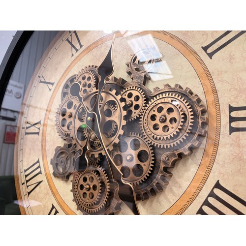 3018 - A black framed 60cm moving gear wall clock with patterned face and brass effect accents