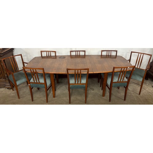 66 - A Gordon Russell teak oval extending dining table and eight chairs