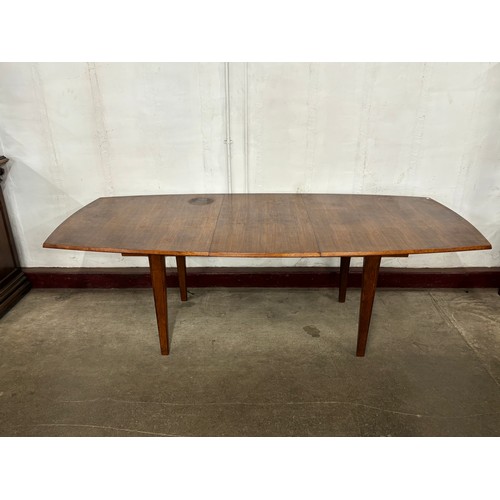 66 - A Gordon Russell teak oval extending dining table and eight chairs