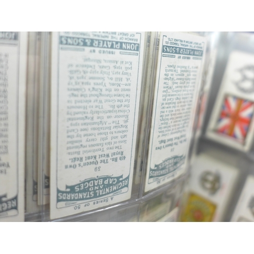 2037 - An album of cigarette card sets all complete, to include; John Player Drum Banners & Cap Badges, Joh... 
