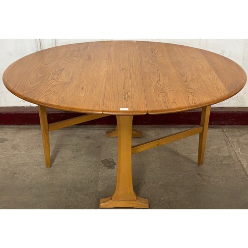 75 - An Ercol Blonde elm and beech drop-leaf table and four Goldsmith chairs