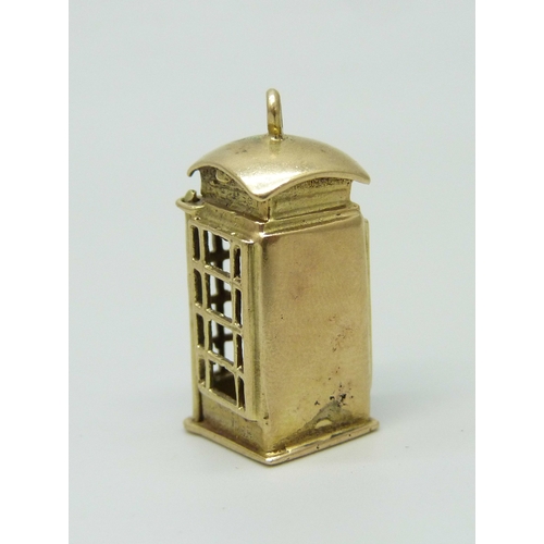 7002 - A 9ct gold charm in the form of a telephone box, the door opens to reveal the interior, hallmarked, ... 