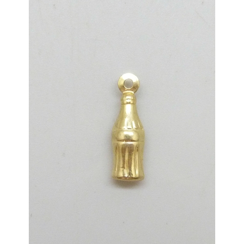 7005 - A yellow metal charm in the form of a Coca Cola style bottle, 0.4g, 1.6cm