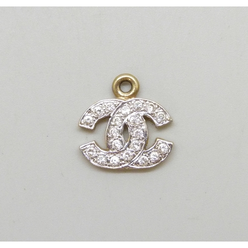 7016 - A yellow metal double C charm set with white stones, 1.5g, 1.4cm