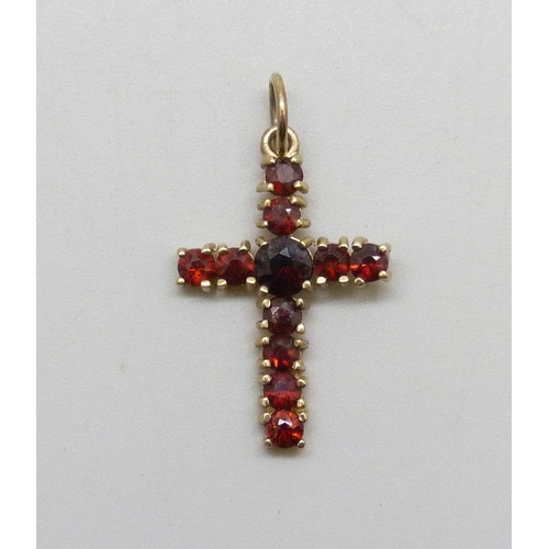7044 - A yellow metal and garnet cross pendant, 0.9g, 2.5cm including bail