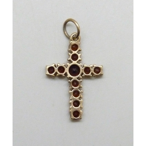 7044 - A yellow metal and garnet cross pendant, 0.9g, 2.5cm including bail