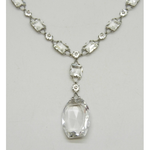 7050 - A 1920s Art Deco platinon and white paste stone riviere drop necklace, the clasp marked Platinon, 18... 