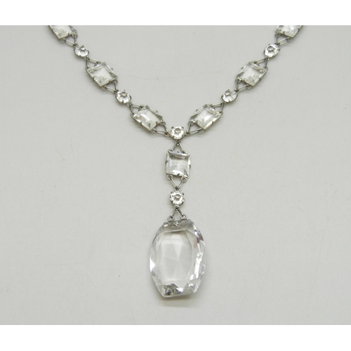 7050 - A 1920s Art Deco platinon and white paste stone riviere drop necklace, the clasp marked Platinon, 18... 