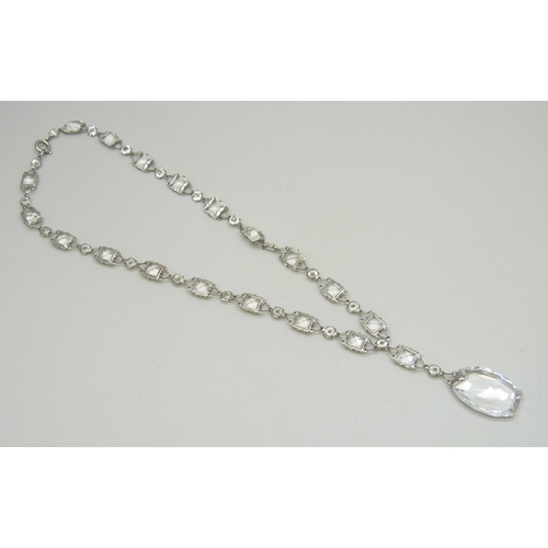 7050 - A 1920s Art Deco platinon and white paste stone riviere drop necklace, the clasp marked Platinon, 18... 