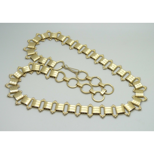 7058 - A Victorian style gold plated book chain, approximately 93cm