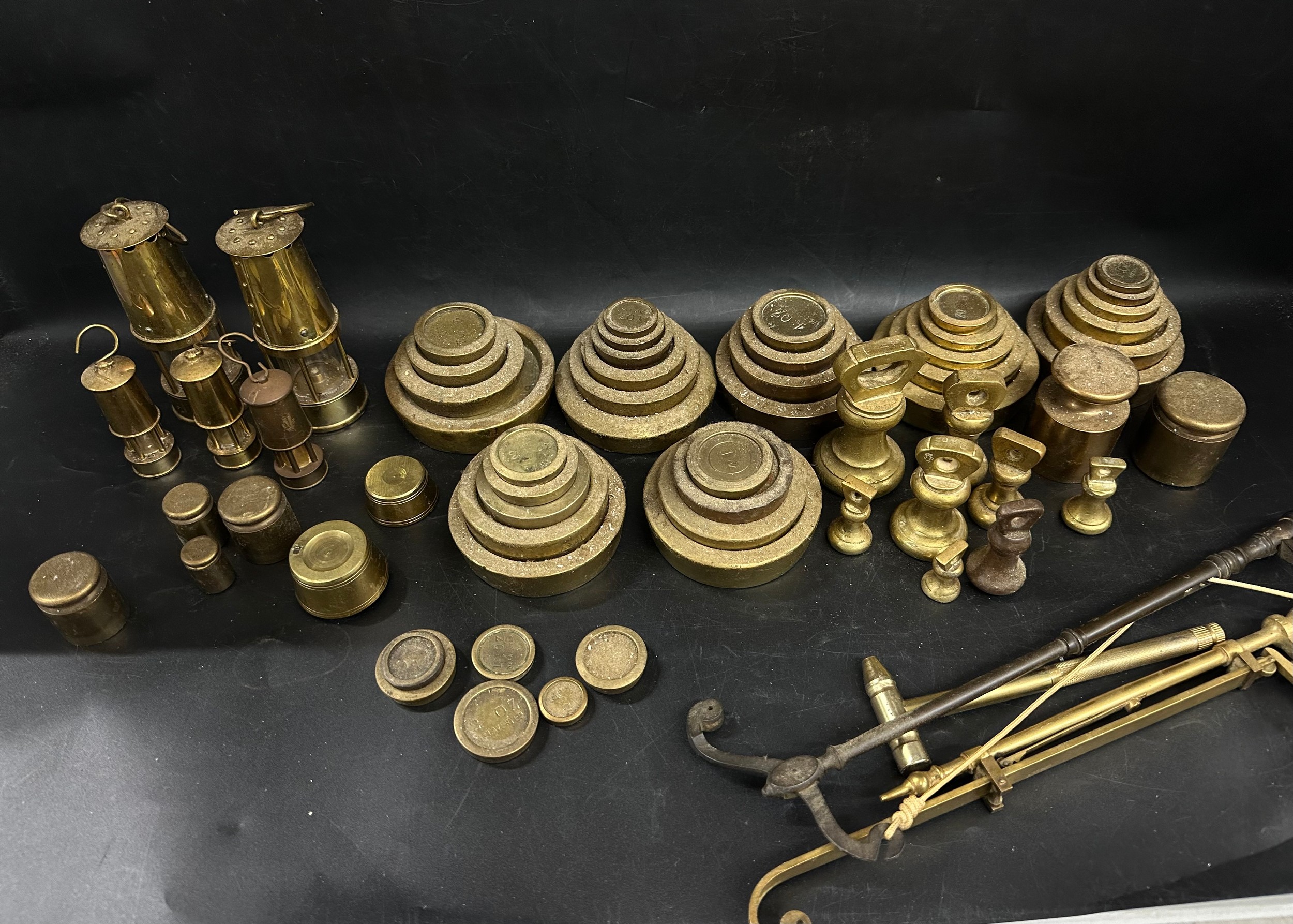 A collection of various sets of brass weights, two small miners lamp, etc.