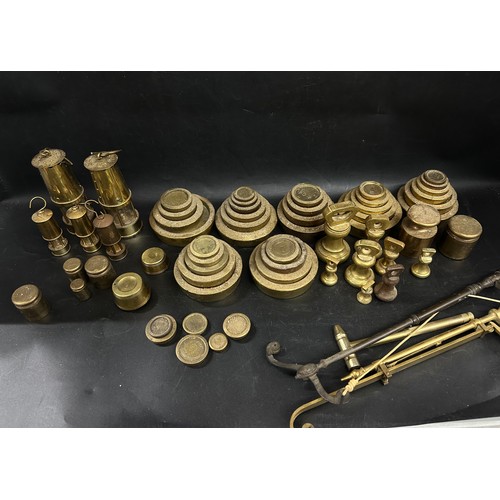A collection of various sets of brass weights, two small miners lamp, etc.