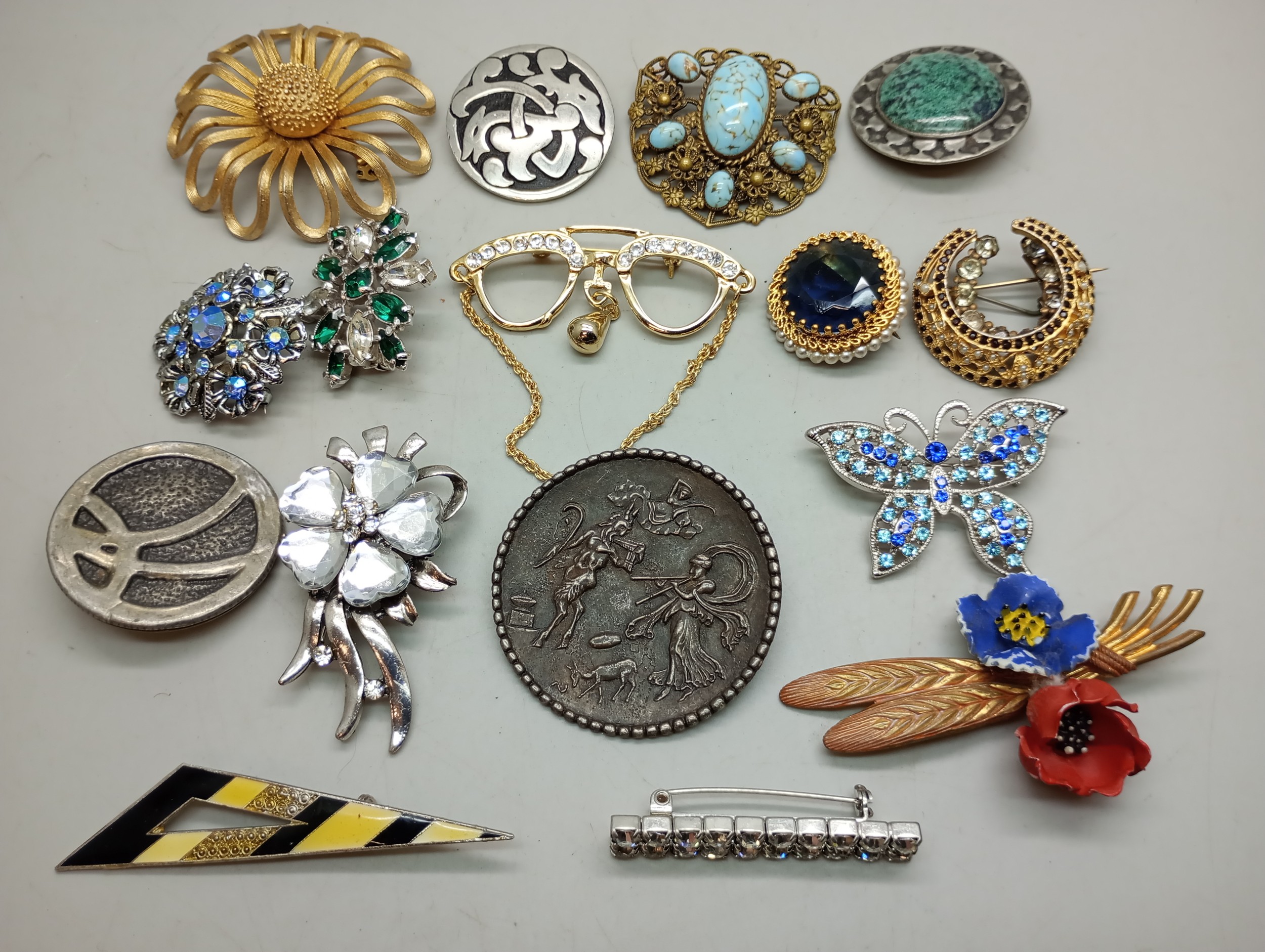 A collection of costume brooches and a clip