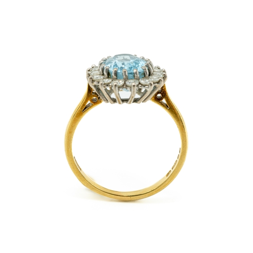 23 - An 18ct yellow gold aquamarine and diamond oval cluster ring, the oval mixed-cut aquamarine surround... 