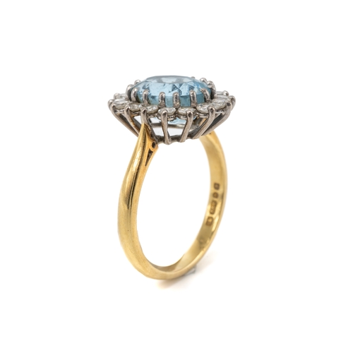 23 - An 18ct yellow gold aquamarine and diamond oval cluster ring, the oval mixed-cut aquamarine surround... 