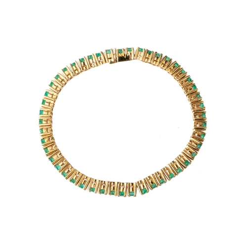 44 - A yellow metal and emerald line bracelet, set with round-cut emeralds in prong settings, box clasp f... 