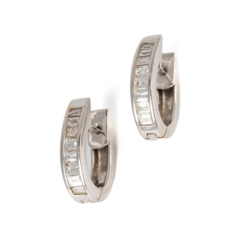 66 - A pair of 18k white gold and diamond huggie hoop earrings, each channel set with eight baguette-cut ... 