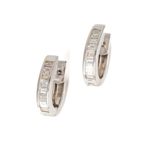 66 - A pair of 18k white gold and diamond huggie hoop earrings, each channel set with eight baguette-cut ... 