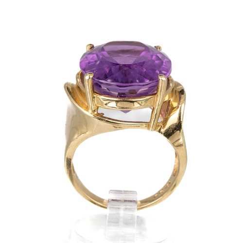 81 - A 10k yellow gold and amethyst dress ring, the large oval amethyst approx 20 x 15 x 10mm, ring size ... 