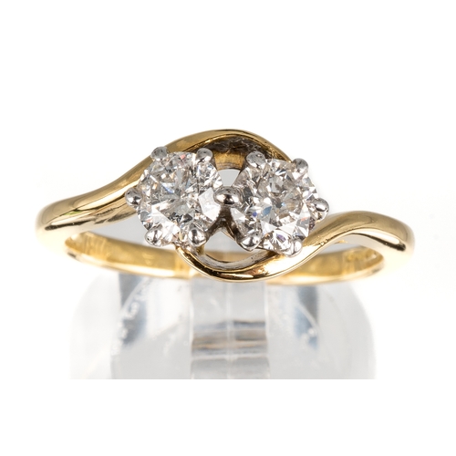 82 - An 18ct yellow gold and diamond two-stone cross-over ring, set with round brilliant-cut diamonds, di... 