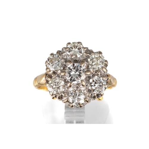 85 - An 18ct yellow gold and diamond seven-stone cluster ring, set with round brilliant-cut diamonds appr... 