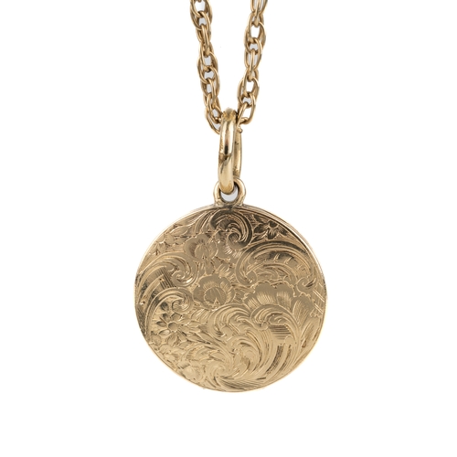 138 - A 19th century yellow metal circular mourning pendant, the cased chased and engraved with foliate sc... 