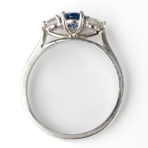 139 - A platinum sapphire and diamond three-stone ring, the central oval-cut sapphire approx 6.8mm x 4.8mm... 