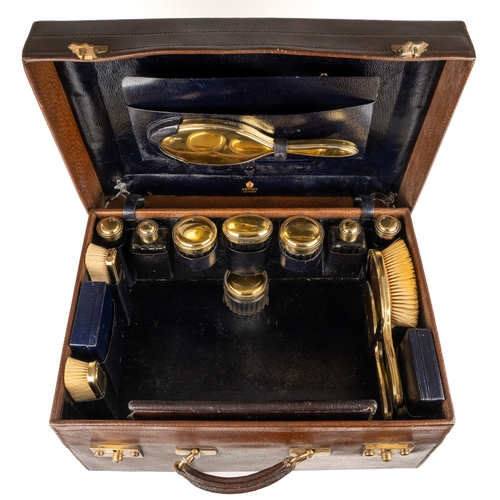 192 - Asprey of London - a George V silver-gilt leather travelling vanity case, comprising two hand brushe... 