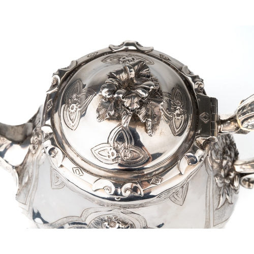 197 - An early Victorian silver teapot, the hinged domed cover with floral finial, the body embossed with ... 