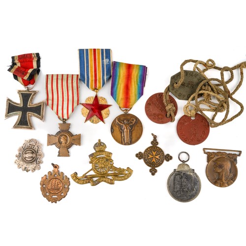 234 - Military interest to include 1939 Iron Cross, French medals, dog tags, cap badges and various coinag... 