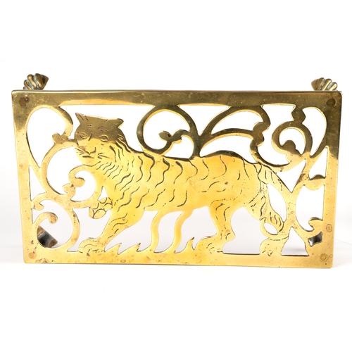 319 - A 19th century rectangular brass trivet, depicting a tiger, raised on four legs with paw feet, appro... 