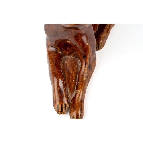 414 - A salt glazed model of a reclining dog / boxer, aprox 15cm long, 8cm high