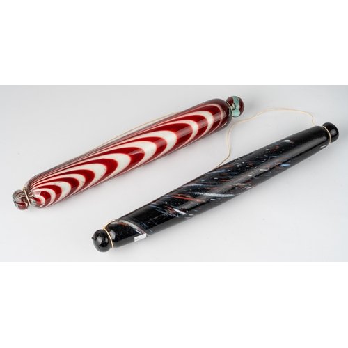 522 - A 'Bristol' glass rolling pin, the clear body with red glass striations full of salt, 36cm long; tog... 