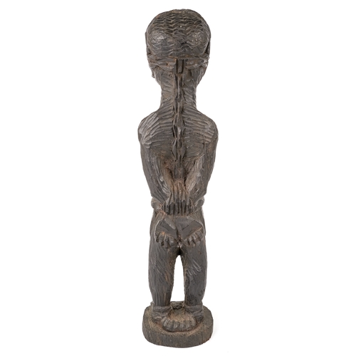 523 - An African carved wooden slave figure in chains and chocker , 37 cm.