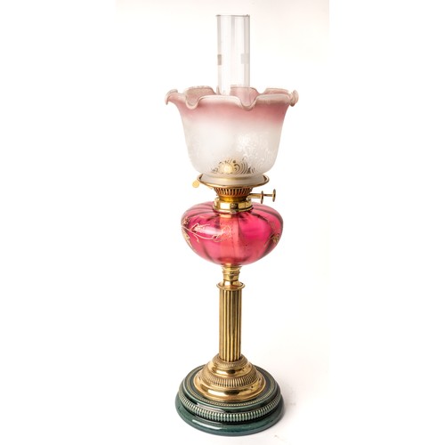 619 - A Victorian oil lamp with majolica base with brass fittings and enamelled cranberry glass body. Appr... 