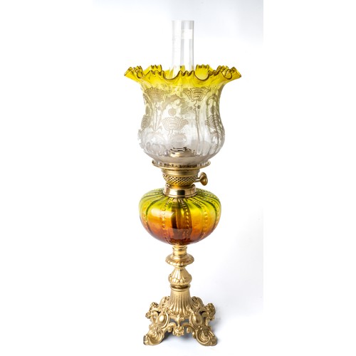 621 - A Victorian oil lamp with gilt metal base, brass fittings,  amber and green body and green etched sh... 