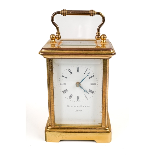 672 - A 20th century Swiss brass carriage clock by Matthew Norman, white enamel dial with Roman numerals, ... 