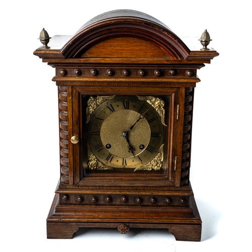 698 - A honey coloured oak bracket clock, glass panelled sides, brass dial with spandrels, acorn finials, ... 