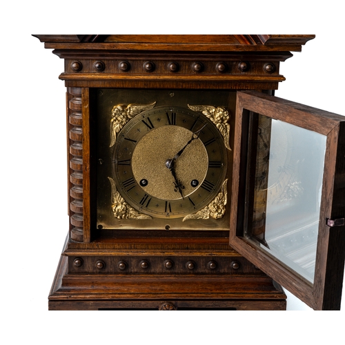 698 - A honey coloured oak bracket clock, glass panelled sides, brass dial with spandrels, acorn finials, ... 