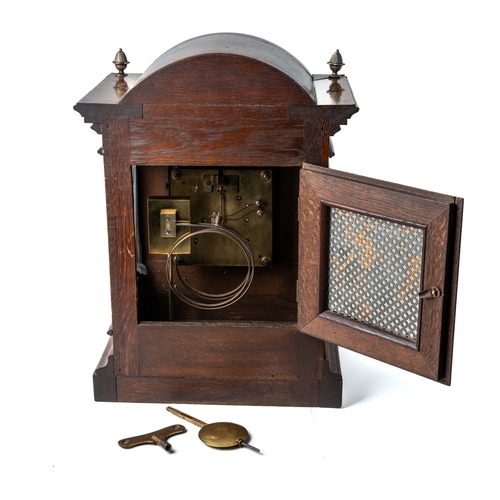 698 - A honey coloured oak bracket clock, glass panelled sides, brass dial with spandrels, acorn finials, ... 