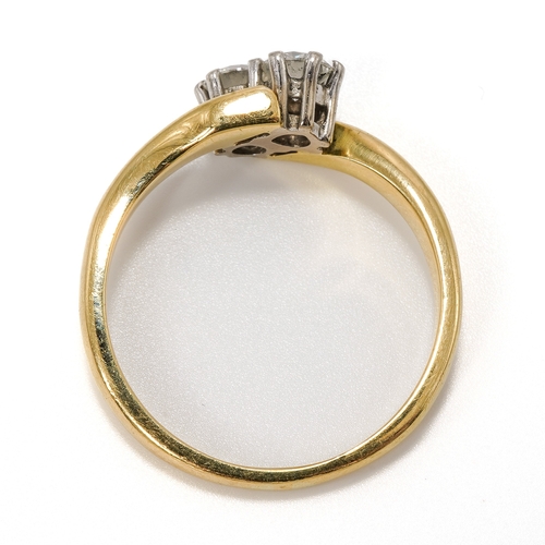 13 - An 18ct yellow gold and diamond two stone crossover ring, set with round brilliant cut diamonds, eac... 