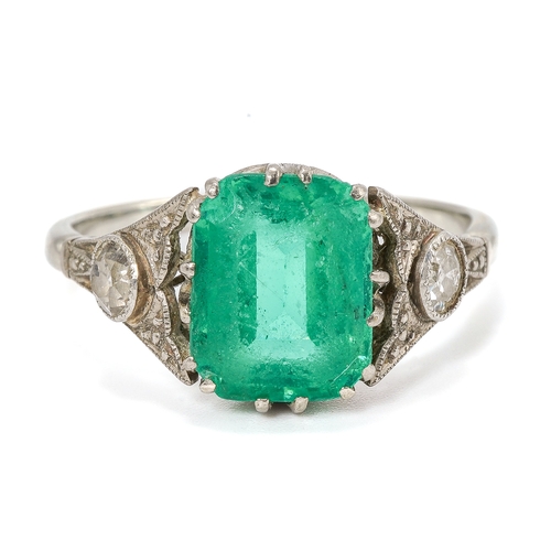 25 - An Art Deco platinum emerald and diamond ring, the emerald approx 9mm x 7mm x 4.4mm, two old-cut dia... 