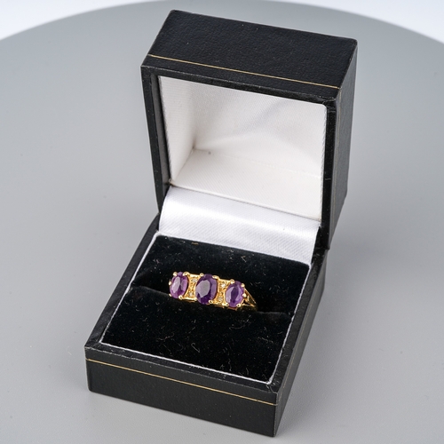 30 - An 18ct yellow gold and amethyst three-stone ring, set with three oval mixed-cut amethyst, diamond c... 